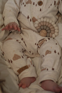 Onesie évolutif beige rosé motif cabanes d’hiver